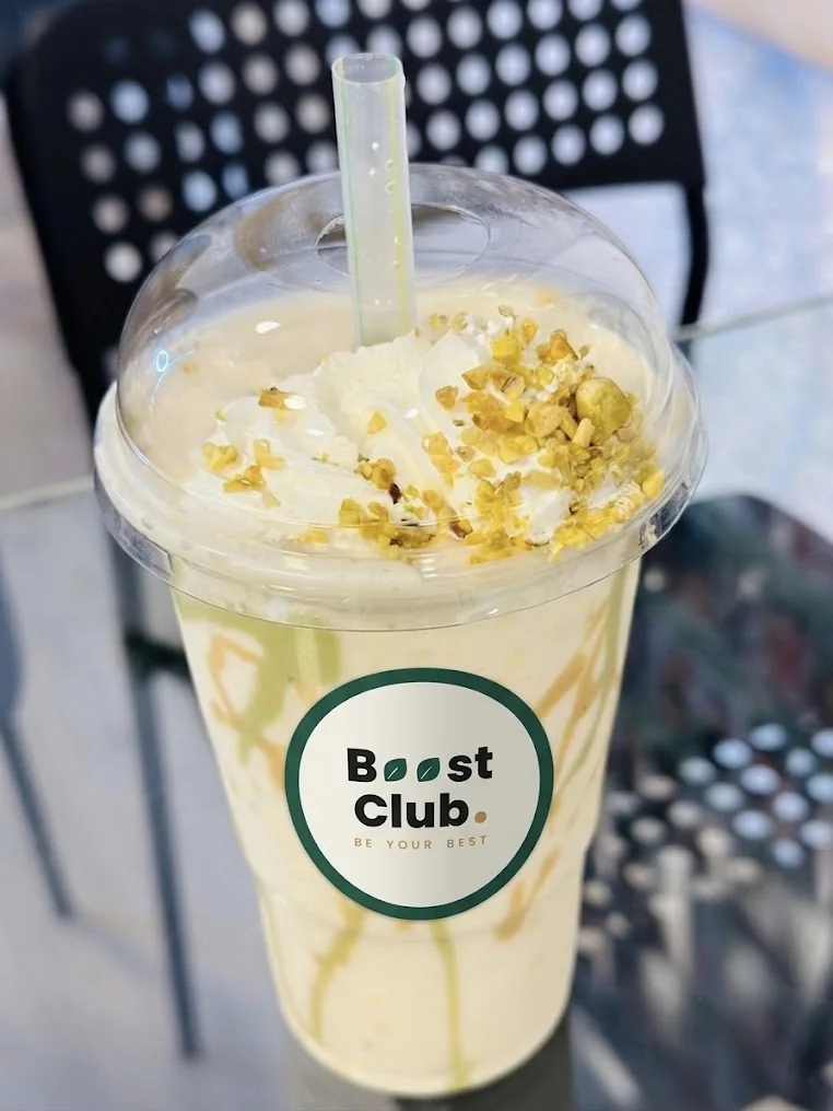O băutură cu topping într-un pahar cu sigla Boost Club