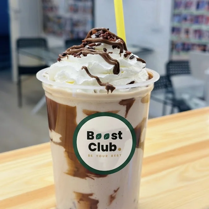 Prim-plan cu o băutură decorată cu frișcă într-un pahar Boost Club